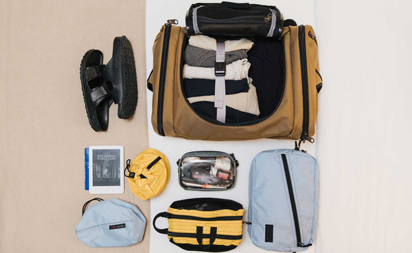 An Aeronaut 45 with various items laid out around it that will be packed inside, including a 3D Clear Organizer Cube.